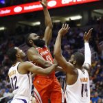 Houston Rockets guard James Harden (13) shoots over Phoenix Suns forward TJ Warren (12) and center Greg Monroe (14) during the first half of an NBA basketball game Thursday, Nov. 16, 2017, in Phoenix. (AP Photo/Ross D. Franklin)
