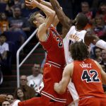 Chicago Bulls forward Lauri Markkanen, left, shoots as he is fouled by Phoenix Suns center Greg Monroe, back right, while Bulls' Robin Lopez (42) watches during the first half of an NBA basketball game Sunday, Nov. 19, 2017, in Phoenix. (AP Photo/Ross D. Franklin)
