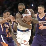 New York Knicks center Kyle O'Quinn, center, protects the ball as he is pressured by Phoenix Suns guard Tyler Ulis, left, and Suns center Alex Len, right, during the third quarter of an NBA basketball game Friday, Nov. 3, 2017, at Madison Square Garden in New York. (AP Photo/Bill Kostroun)