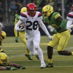 Arizona's Nick Wilson breaks through the Oregon defense for a 18-yard touchdown run in the first quarter of an NCAA college football game, Saturday, Nov. 18, 2017, in Eugene, Ore. (AP Photo/Chris Pietsch)