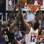 Brooklyn Nets forward Quincy Acy (13) pulls the ball away from Phoenix Suns forward TJ Warren (12) during the first half of an NBA basketball game Monday, Nov. 6, 2017, in Phoenix. (AP Photo/Ross D. Franklin)