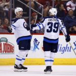 Winnipeg Jets center Matt Hendricks (15) celebrates his goal against the Arizona Coyotes with Jets defenseman Toby Enstrom (39) during the second period of an NHL hockey game Saturday, Nov. 11, 2017, in Glendale, Ariz. (AP Photo/Ross D. Franklin)