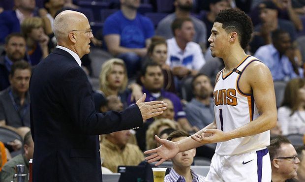 Phoenix Suns guard Devin Booker (1) slaps hands with interim head coach Jay Triano, left, as Booker...