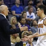Phoenix Suns guard Devin Booker (1) slaps hands with interim head coach Jay Triano, left, as Booker comes out of the game during the second half of an NBA basketball game against the Brooklyn Nets Monday, Nov. 6, 2017, in Phoenix. The Nets defeated the Suns 98-92. (AP Photo/Ross D. Franklin)