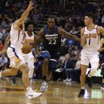 Minnesota Timberwolves forward Andrew Wiggins (22) drives between Phoenix Suns guard Mike James and Devin Booker (1) in the first half during an NBA basketball game, Saturday, Nov 11, 2017, in Phoenix. (AP Photo/Rick Scuteri)