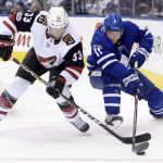 Arizona Coyotes defenseman Alex Goligoski (33) and Toronto Maple Leafs centre Zach Hyman (11) battle for the puck along the boards during second period NHL hockey action in Toronto on Monday, Nov. 20, 2017. (Nathan Denette/The Canadian Press via AP)