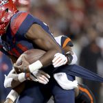 Arizona quarterback Khalil Tate (14) drags a couple of Oregon State defenders into the end zone on a touchdown run during the second quarter of an NCAA college football game Saturday, Nov. 11, 2017, Tucson, Ariz. (Kelly Presnell/Arizona Daily Star via AP)