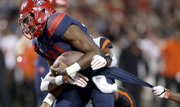 Arizona quarterback Khalil Tate (14) drags a couple of Oregon State defenders into the end zone on ...