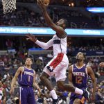Washington Wizards guard John Wall (2) goes to the basket past Phoenix Suns forward TJ Warren (12) and guard Devin Booker (1) during the first half of an NBA basketball game, Wednesday, Nov. 1, 2017, in Washington. (AP Photo/Nick Wass)