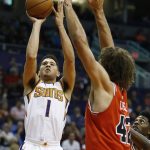 Phoenix Suns guard Devin Booker (1) shoots over Chicago Bulls center Robin Lopez (42) during the first half of an NBA basketball game Sunday, Nov. 19, 2017, in Phoenix. (AP Photo/Ross D. Franklin)