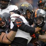 Arizona State running back Demario Richards, center, is stopped by a pair of Oregon State defenders in the second half of an NCAA college football game in Corvallis, Ore., Saturday, Nov. 18, 2017. (AP Photo/Timothy J. Gonzalez)