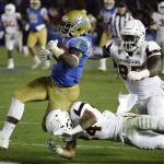 UCLA running back Bolu Olorunfunmi, left, runs past Arizona State defensive lineman Renell Wren, top right, and defensive back Chase Lucas during the second half of an NCAA college football game in Pasadena, Calif., Saturday, Nov. 11, 2017. UCLA won 44-37. (AP Photo/Chris Carlson)