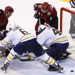 Buffalo Sabres goalie Robin Lehner, right, looks for the puck as he gets some help from Marco Scandella (6) as Arizona Coyotes center Christian Dvorak (18) and Coyotes' Clayton Keller (9) try to get sticks on the puck during the third period of an NHL hockey game Thursday, Nov. 2, 2017, in Glendale, Ariz. The Sabres won 5-4. (AP Photo/Ross D. Franklin)