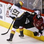 Vegas Golden Knights right wing Reilly Smith (19) checks Arizona Coyotes left wing Jordan Martinook (48) into the boards during the first period of an NHL hockey game Saturday, Nov. 25, 2017, in Glendale, Ariz. (AP Photo/Ross D. Franklin)