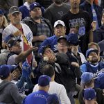 Fans try for a foul ball hit by Los Angeles Dodgers second baseman Logan Forsythe during the fourth inning of Game 7 of baseball's World Series against the Houston Astros Wednesday, Nov. 1, 2017, in Los Angeles. (AP Photo/Mark J. Terrill)