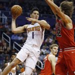 Phoenix Suns guard Devin Booker (1) looks to pass the ball as Chicago Bulls center Robin Lopez (42) defends while Bulls' Lauri Markkanen, middle, watches during the first half of an NBA basketball game Sunday, Nov. 19, 2017, in Phoenix. (AP Photo/Ross D. Franklin)
