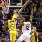 Phoenix Suns forward TJ Warren (12) has his shot blocked by Los Angeles Lakers center Brook Lopez, back left, as Lakers' Brandon Ingram (14) and Lonzo Ball (2) look on during the first half of an NBA basketball game Monday, Nov. 13, 2017, in Phoenix. (AP Photo/Ross D. Franklin)