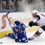 Toronto Maple Leafs center Mitchell Marner (16) loses his edge and falls in the corner as Arizona Coyotes defenseman Jason Demers (55) defends during first-period NHL hockey game action in Toronto, Monday, Nov. 20, 2017. (Nathan Denette/The Canadian Press via AP)