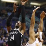 Brooklyn Nets forward Rondae Hollis-Jefferson (24) gets a shot off over Phoenix Suns forward Jared Dudley (3) during the first half of an NBA basketball game Monday, Nov. 6, 2017, in Phoenix. (AP Photo/Ross D. Franklin)