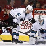 San Jose Sharks goalie Martin Jones (31) makes a save as Sharks defenseman Justin Braun (61) keeps Arizona Coyotes center Christian Dvorak (18) away from the puck during the first period of an NHL hockey game Wednesday, Nov. 22, 2017, in Glendale, Ariz. The Sharks defeated the Coyotes 3-1. (AP Photo/Ross D. Franklin)