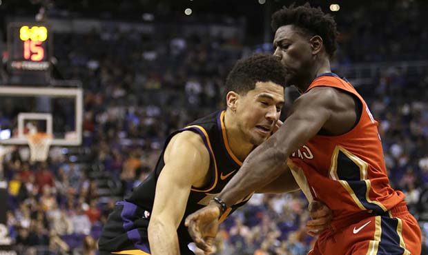 Phoenix Suns guard Devin Booker (1) drives against New Orleans Pelicans guard Jrue Holiday in the s...