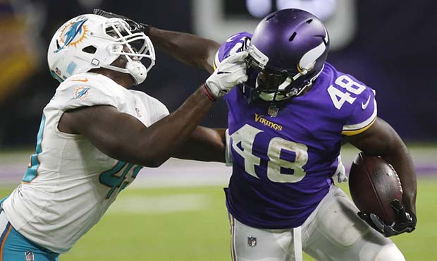 Minnesota Vikings running back Bronson Hill (48) tries to break a tackle by Miami Dolphins lineback...