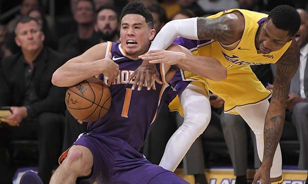 Phoenix Suns guard Devin Booker, left, and Los Angeles Lakers guard Kentavious Caldwell-Pope compet...