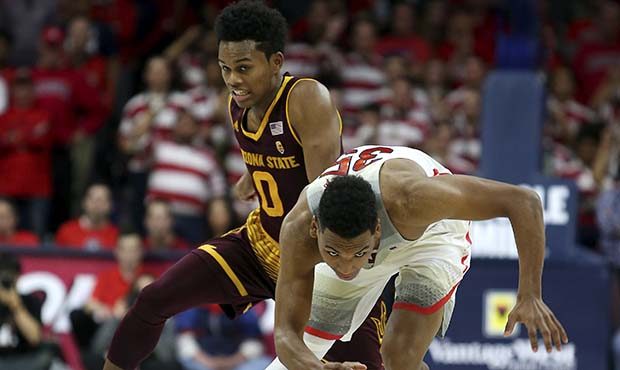 Arizona guard Allonzo Trier (35) stumbles as Tra Holder (0) tries to steal the ball during the seco...