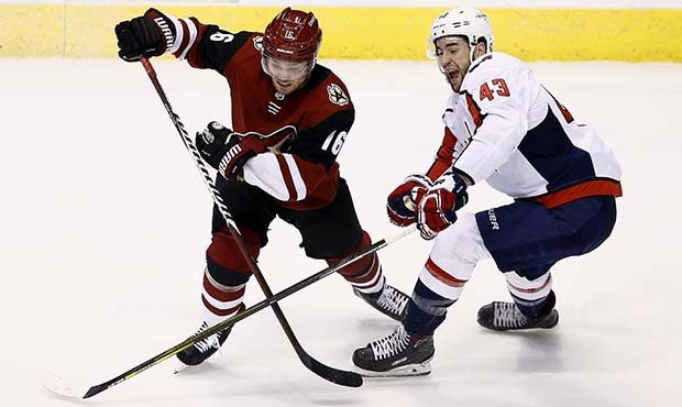 Arizona Coyotes left wing Max Domi (16) battles with Washington Capitals right wing Tom Wilson (43)...
