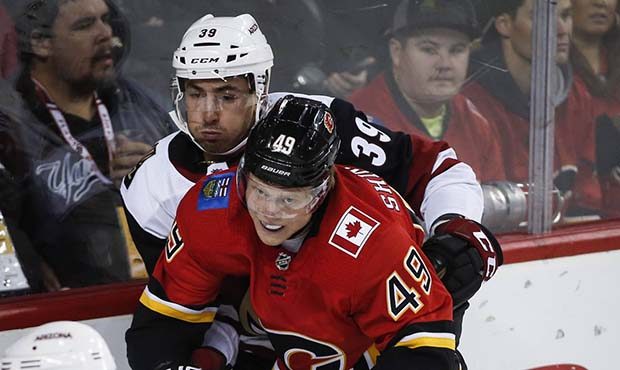 Arizona Coyotes' Joel Hanley, left, is checked by Calgary Flames' Hunter Shinkaruk during the first...