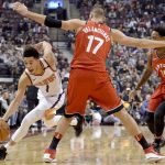 Phoenix Suns guard Devin Booker (1) moves the ball around Toronto Raptors' Joan Valanciunas during the first half of an NBA basketball game Tuesday, Dec. 5, 2017, in Toronto. (Nathan Denette/The Canadian Press via AP