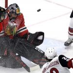 Chicago Blackhawks goalie Corey Crawford, second from left, blocks a shot by Arizona Coyotes defenseman Oliver Ekman-Larsson, lower right, during the second period of an NHL hockey game Sunday, Dec. 10, 2017, in Chicago. (AP Photo/Nam Y. Huh)