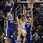 Phoenix Suns guard Devin Booker (1) has his shot altered by Philadelphia 76ers forward Dario Saric (9) and guard Ben Simmons (25) during the first half of an NBA basketball game, Sunday, Dec. 31, 2017, in Phoenix. (AP Photo/Ross D. Franklin)