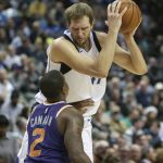 Dallas Mavericks forward Dirk Nowitzki, top, of Germany, is defended by Phoenix Suns Isaiah Canaan (2) during the first half of an NBA basketball game in Dallas, Monday, Dec. 18, 2017. (AP Photo/LM Otero)