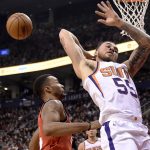 Phoenix Suns guard Mike James (55) tries to pass the ball backward, next to Toronto Raptors forward Norman Powell (24) during the first half of an NBA basketball game Tuesday, Dec. 5, 2017, in Toronto. (Nathan Denette/The Canadian Press via AP)