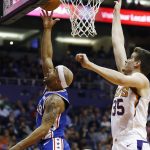 Philadelphia 76ers guard Jerryd Bayless, left, gets past Phoenix Suns forward Dragan Bender (35) to score during the first half of an NBA basketball game Sunday, Dec. 31, 2017, in Phoenix. (AP Photo/Ross D. Franklin)