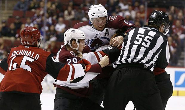 Arizona Coyotes right wing Josh Archibald (45) tries to help out center Zac Rinaldo, back right, as...