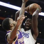 Los Angeles Clippers forward Montrezl Harrell, right, shoots over Phoenix Suns guard Troy Daniels during the second half of an NBA basketball game in Los Angeles, Wednesday, Dec. 20, 2017. The Clippers won 108-95. (AP Photo/Chris Carlson)