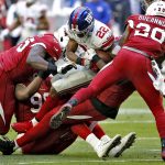 New York Giants running back Wayne Gallman (22) is tackled Arizona Cardinals defensive end Rodney Gunter, left, and nose tackle Corey Peters, on ground, during the first half of an NFL football game, Sunday, Dec. 24, 2017, in Glendale, Ariz. (AP Photo/Ross D. Franklin)