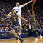 Kansas guard Sviatoslav Mykhailiuk (10) tips the ball to a teammate while covered by Arizona State forward Mickey Mitchell (3) and guard Tra Holder (0) during the first half of an NCAA college basketball game in Lawrence, Kan., Sunday, Dec. 10, 2017. (AP Photo/Orlin Wagner)