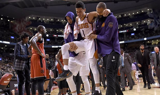 Phoenix Suns guard Devin Booker (1) is carried off by teammates during the second half of an NBA ba...