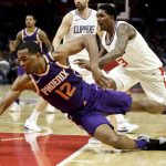 Phoenix Suns forward TJ Warren, left, dives for a loose ball past Los Angeles Clippers guard Lou Williams during the first half of an NBA basketball game in Los Angeles, Wednesday, Dec. 20, 2017. (AP Photo/Chris Carlson)