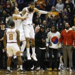 Phoenix Suns center Tyson Chandler, right, celebrates his winning score against the Memphis Grizzlies with Suns guard Devin Booker, second from left, and Suns guard Isaiah Canaan (2) during the second half of an NBA basketball game, Tuesday, Dec. 26, 2017, in Phoenix. The Suns defeated the Grizzlies 99-97. (AP Photo/Ross D. Franklin)