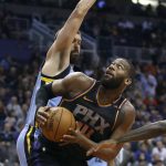 Phoenix Suns center Greg Monroe (14) looks to shoot the ball around the defense of Memphis Grizzlies' Marc Gasol during the first half of an NBA basketball game Thursday, Dec. 21, 2017, in Phoenix. (AP Photo/Ralph Freso)