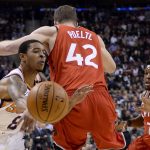 Phoenix Suns guard Tyler Ulis (8) moves the ball around Toronto Raptors center Jakob Poeltl (42) as Raptors guard Kyle Lowry (7 watches during the first half of an NBA basketball game Tuesday, Dec. 5, 2017, in Toronto. (Nathan Denette/The Canadian Press via AP