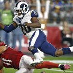 Arizona Cardinals wide receiver Larry Fitzgerald (11) scores a touchdown as Los Angeles Rams free safety Lamarcus Joyner (20) defends during the first half of an NFL football game, Sunday, Dec. 3, 2017, in Glendale, Ariz. (AP Photo/Ross D. Franklin)