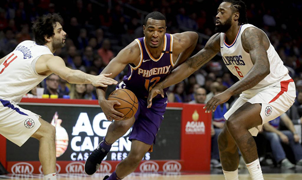 Phoenix Suns forward TJ Warren, middle, drives to the basket between Los Angeles Clippers guard Mil...