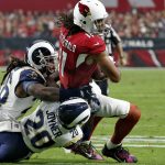 Arizona Cardinals wide receiver Larry Fitzgerald (11) is hit by Los Angeles Rams free safety Lamarcus Joyner (20) and Mark Barron during the first half of an NFL football game, Sunday, Dec. 3, 2017, in Glendale, Ariz. (AP Photo/Ross D. Franklin)