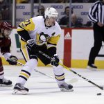 Pittsburgh Penguins center Evgeni Malkin (71) carries the puck in front of Arizona Coyotes right wing Tobias Rieder in the first period during an NHL hockey game, Saturday, Dec. 16, 2017, in Glendale, Ariz. (AP Photo/Rick Scuteri)