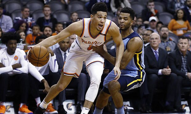 Back from injury, Phoenix Suns guard Devin Booker (1) dribbles past Memphis Grizzlies guard Andrew ...